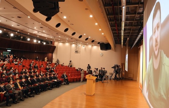 １１日に韓国国会図書館大講堂で行われたゼレンスキー大統領のビデオ演説。与野３党の指導部など５０人ほどの議員が前方の座席を埋めたが多くの議員が参加せず大講堂左側と右側、後方の座席は空いたまま演説が行われた。［写真　国会写真記者団］