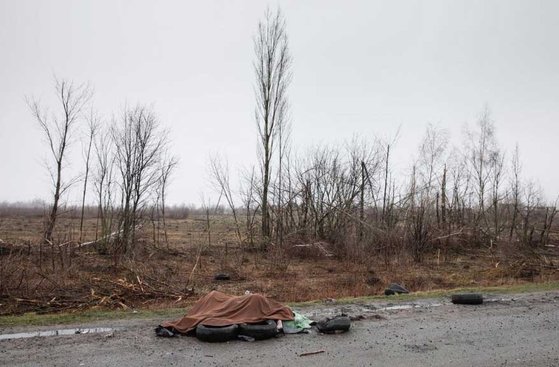 ４月３日、写真作家ミハイル・パリンチャク（Ｍｉｋｈａｉｌ　Ｐａｌｉｎｃｈａｋ）氏がインスタグラムに該当の写真とあわせて「２日、ウクライナ首都キーウ（キエフ）から２０キロメートル離れたある高速道路で民間人の死亡者が目撃された。茶色の毛布の中には民間人男性１人と全裸の女性２～３人の遺体があり、身体の一部は焼けていた」とコメントした。