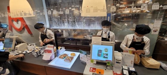 東京・上野駅前にあるベーカリー「アンデルセン」にはＡＩ計算機「ベーカリースキャン」（中央）が導入されている。１００種類を超えるパンを認識し、パンが載せられたトレーを置くだけで自動で計算してくれる。パン計算に適用したＡＩ技術はがん細胞研究につながったりもした。［写真　キム・ヒョンイェ東京特派員］