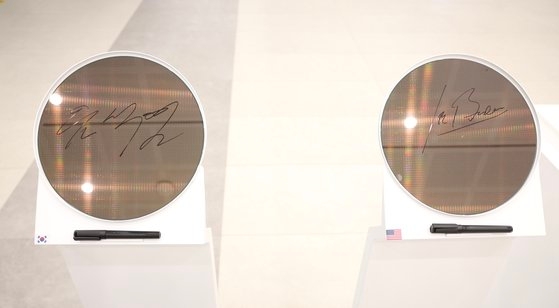 尹錫悦大統領とバイデン米大統領は２０日、京畿道平沢のサムスン電子半導体工場で、世界で初めて量産予定の３ナノメートルプロセスのウエハーに署名を残した。［写真　大統領室写真記者団］