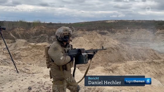 ウクライナで機関銃を発射しているイ・グン氏（写真　ターゲスシャウ放送）