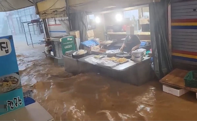 雨水であふれる仁川第一市場に閉じ込められた商人。［写真　聯合ニュース］