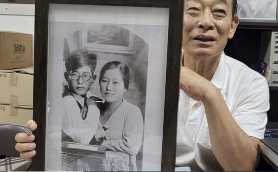 １９２５年、モスクワ留学前に金命時将軍（右）と弟キム・ヒョンユンが共に撮った写真を持いながらキム・ヨンマン開かれた社会希望連帯常任顧問が金将軍の功績を説明している。　アン・テフン記者