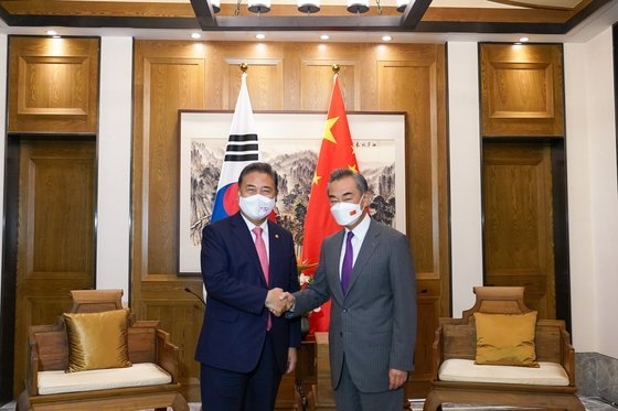 韓国の朴振（パク・ジン）外交部長官（左）が９日、中国山東省で中国の王毅国務委員兼外交部長と会って握手している。［写真　外交部］