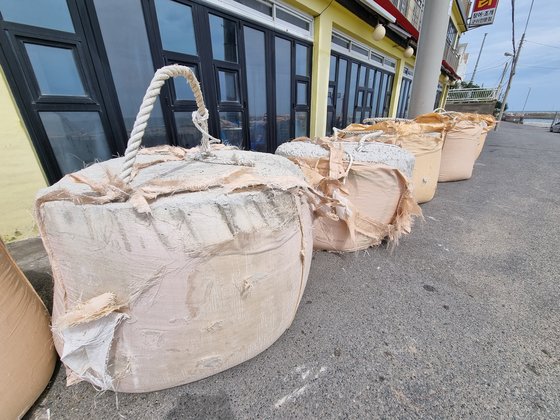 １８日午前、釜山海雲台区青沙浦（プサン・ヘウンデグ・チョンサポ）の飲食店前に台風１４号「ＮＡＮＭＡＤＯＬ（ナンマドル）」の接近に備えたコンクリートブロックが築かれている。［写真　ソン・ボングン記者］