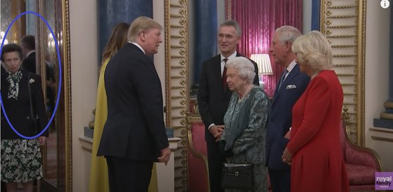 トランプ大統領夫妻が英ロンドンのバッキンガム宮殿を訪問した当時の写真。アン王女（一番左の青い円の中）がトランプ大統領を注視している。　写真＝ユーチューブ　キャプチャー　https://www.youtube.com/watch?v=CnQ9dddBWAk