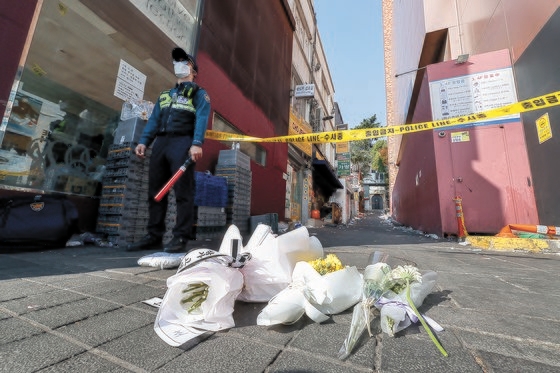 事故犠牲者を追悼する市民が１０月３０日に事故現場に近いソウル・梨泰院のハミルトンホテル前に置かれた弔花の前で酒を注いでいる。キム・ソンリョン記者