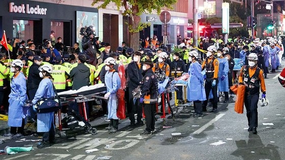 ２９日夜、ソウル龍山区梨泰院洞のハミルトンホテル近くの路地で大規模な転倒事故が発生した中、翌日の３０日未明ハミルトンホテル前近くの道路で救助隊員が担架に事故犠牲者をのせて搬送している。ウ・サンジョ記者