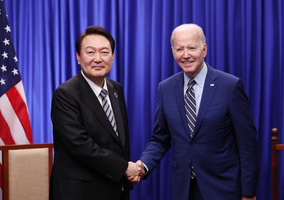 韓国の尹錫悦（ユン・ソクヨル）大統領が１３日（現地時間）、カンボジア・プノンペンのあるホテルで開かれた韓米首脳会談で米国のバイデン大統領と握手している。［写真　韓国大統領室］