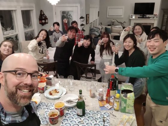 米ニューヨーク州の住民アレクサンダー・カンパーニャさん（写真左）が大雪で足止めされた韓国人観光客９人を含む１０人を家に迎え入れ、クリスマス休暇を一緒に過ごす様子。［カンパーニャさんのフェイスブックキャプチャー］