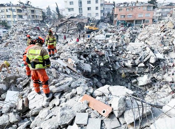 ６日（現地時間）、地震被害を受けたトルコ（テュルキエ）で緊急救助活動を行っている韓国海外緊急救護隊（ＫＤＲＴ）。現場では完全に倒壊した建物のがれきと暗いくぼみの中を掘って救助作業が行われている。［写真　ＫＤＲＴ］