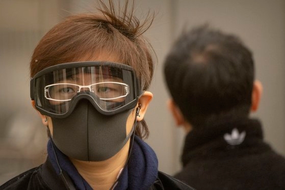 黄砂を避けるためにゴーグルとマスクをつけた北京の市民［写真　ＡＰ＝聯合ニュース］