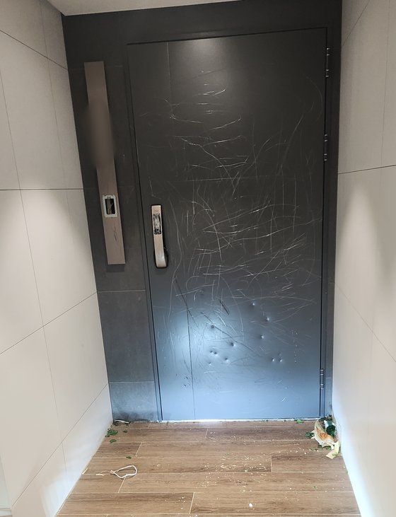 ６日、ソウル江南区のある新築マンションで、ある男性がマンションのドアを滅多切りにして立ち去り、警察が捜査に乗り出した。防犯カメラなどによると、男性は面識犯ではないことが分かった。［写真　マンションコミュニティ］