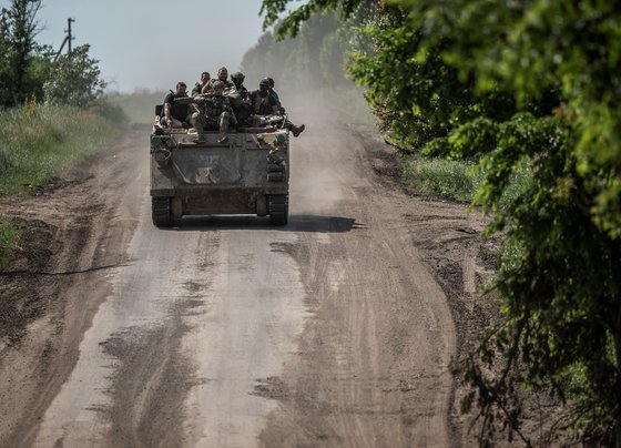 装甲車に乗り移動するウクライナ兵。［写真　ロイター＝聯合ニュース］