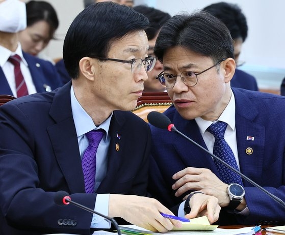 劉国熙（ユ・グクヒ）原子力安全委員会委員長が１５日、国会政務委員会で方文圭（パン・ムンギュ）国務調整室長と言葉を交わしている。　キム・ヒョンドン記者