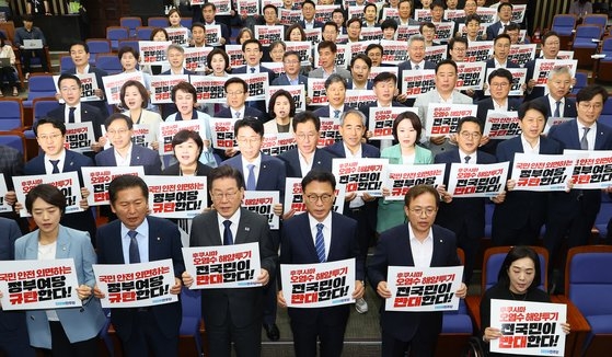 共に民主党の李在明代表をはじめとする議員たちが６月２１日、国会政策議員総会で福島汚染水放流を糾弾するピケットを持ってスローガンを叫んでいる。キム・ヒョンドン記者