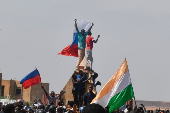 ニジェールとロシアの国旗を振るデモ隊［写真　ＡＦＰ＝聯合ニュース］