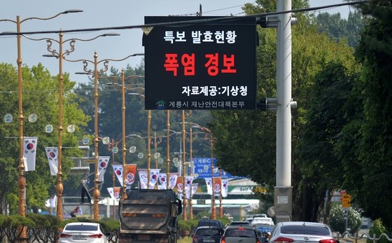 連日、蒸し暑さが全国で猛威を振るっている中、１日午後、忠清南道鶏龍市（チュンチョンナムド・ケリョンシ）の大通り沿いに設置された災害安全対策本部の電光掲示板が猛暑警報発令を知らせている。キム・ソンテ記者