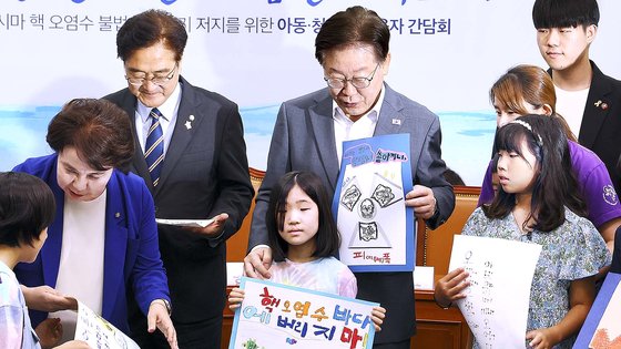 韓国最大野党・共に民主党の李在明（イ・ジェミョン）代表と議員らが８日、国会で開かれた「福島汚染水海洋投棄阻止のための児童青少年養育者懇談会」参加者と記念撮影をしている。　キム・ヒョンドン記者