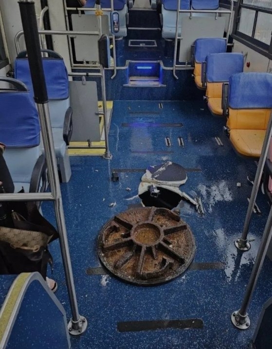 台風６号の大雨で、吹き上がって市内バスの床を突き破ったマンホールの蓋。［写真　オンライン・コミュニティ］