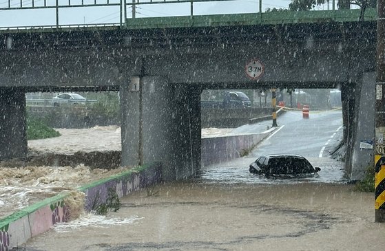 １０日午前９時４５分ごろ、慶山市南川面では河川が氾濫し、地下車道で車１台が孤立した。［写真　慶北消防本部］