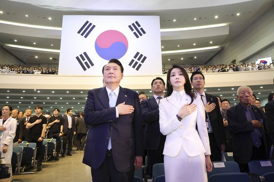 尹錫悦（ユン・ソクヨル）大統領と金建希（キム・ゴンヒ）夫人が１５日、ソウル西大門区（ソデムング）梨花（イファ）女子大学大講堂で開かれた第７８周年光復節慶祝式典で、国旗に対して敬礼をしている。［写真　韓国大統領室］