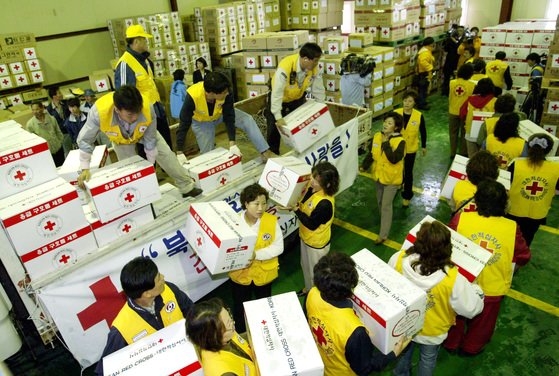 ２００４年、大韓赤十字社のボランティアメンバーが京畿道高陽市（コヤンシ）の大韓通運一山（イルサン）倉庫で、北朝鮮龍川（ヨンチョン）駅爆発事故現場に送る救護品をトラックから下ろしている。　中央ＤＢ