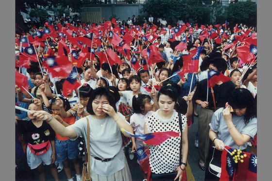 韓中修交で台湾との外交関係が断絶した１９９２年８月２４日午後４時、ソウル明洞（ミョンドン）にある台湾大使館で最後に挙行された国旗降納式に殺到した華僑が台湾の国旗である青天白日旗が下される様子を見守りながら涙を流している。［中央フォト］