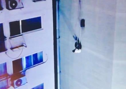 エアコンの線に掛かってビルの外壁で宙吊りになった２０代の男性／聯合ニュース