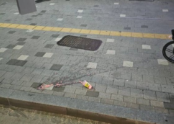 今月７日、ソウルのあるバス停留所。飲料のカップと中身の液体が路上に散らばっている。［写真　Ｘ（旧ツイッター）　キャプチャー］
