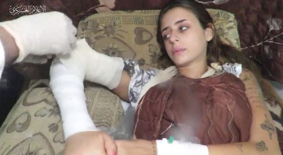 ハマスから腕の治療を受けるイスラエル人捕虜。［Ｘ（旧ツイッター）　キャプチャー］