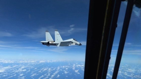 中国戦闘機が米国空軍の航空機に近接飛行する様子。［写真　ロイター＝聯合］