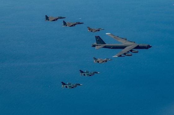 米空軍戦略爆撃機Ｂ－５２Ｈ「ストラトフォートレス」と韓日米戦闘機が２２日、韓日防空識別区域が重なる上空で連合空中訓練を実施している。３カ国の空軍が一緒に空中訓練を行ったのは今回が初めて。上から空軍Ｆ－１５Ｋ２機、米空軍Ｆ－１６、Ｂ－５２Ｈ、Ｆ－１６、日本航空自衛隊Ｆ－２２機。［写真　米空軍］