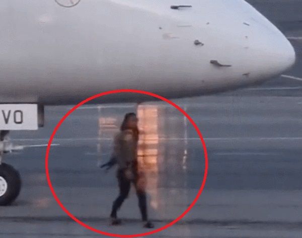 豪キャンベラ空港の滑走路で飛行機に近づく女性　［写真　Ｘ］