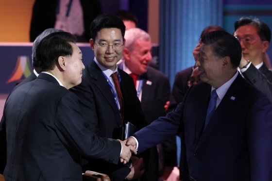 韓国の尹錫悦（ユン・ソクヨル）大統領が１６日（現地時間）、米国サンフランシスコのモスコーニセンターで開かれたアジア太平洋経済協力（ＡＰＥＣ）最初の首脳会議セッションで中国の習近平国家主席と会って握手している。［写真　韓国大統領室］