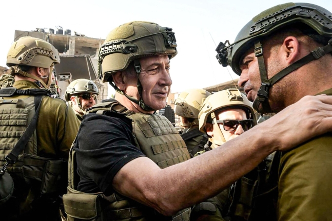 イスラエルのネタニヤフ首相（中央）がパレスチナ武装政派ハマスと一時休戦３日目の２６日（現地時間）、ガザ地区を訪問して兵士らに会っている。［写真　イスラエル首相室］