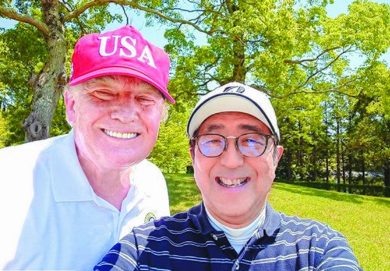 ゴルフの後に記念撮影をしているトランプ氏と安倍氏。［写真　聯合ニュース］