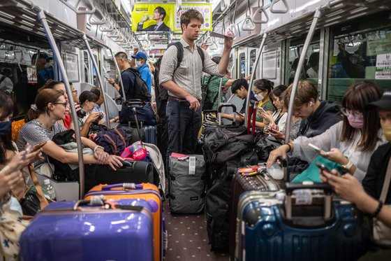 外国人観光客のスーツケーツで通路が狭くなった電車内部。［写真　ＡＦＰ＝聯合ニュース］