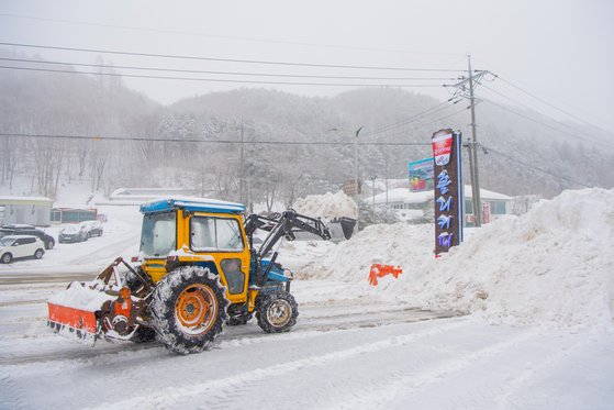 江原高城（カンウォン・コソン）地域に３０センチ前後の雪が降った中、２１日午前、除雪車が除雪作業を行っている。［写真　高城郡］