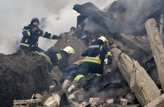 ロシア軍の空爆により崩れた建物の残骸を捜索する救助隊員。［写真　ＥＰＡ＝聯合ニュース］