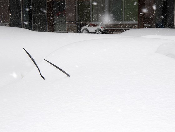 大雪に埋もれてワイパーだけが突き出た車両。［写真　江原道高城郡］