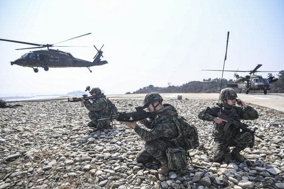 海兵隊員が１５日、仁川市甕津郡の白翎島・延坪島一帯で実施された西北島嶼増援訓練に参加し、作戦を遂行している。海兵隊の攻撃ヘリコプターと機動ヘリコプターが訓練に投入された。　［写真　海兵隊］