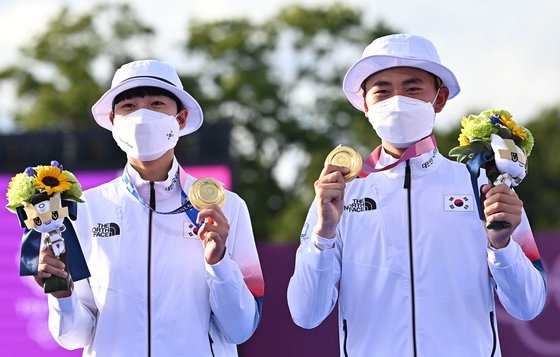 アーチェリー韓国代表の安山（アン・サン、左）が東京五輪混合団体戦決勝で金メダルを獲得しポーズを取っている。