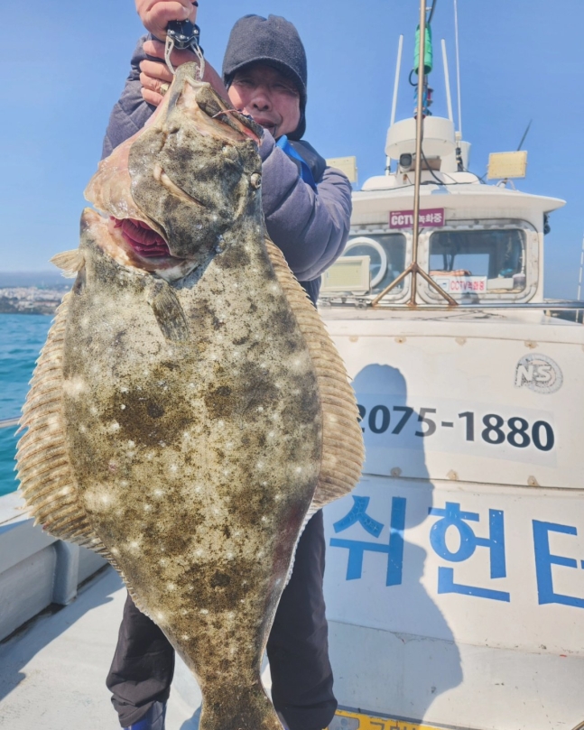 超大型ヒラメを釣った釣り人［写真　聯合ニュース］