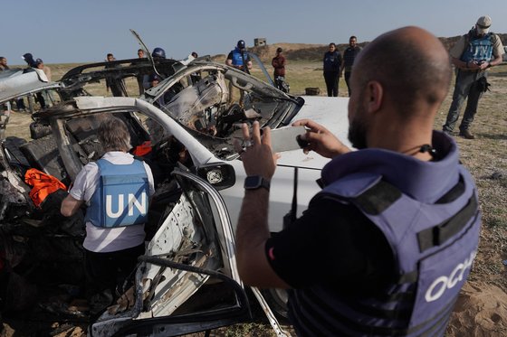 イスラエル国防軍の空襲を受けた車体を調査する国連職員。［写真　ＡＦＰ＝聯合ニュース］