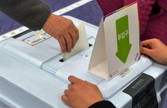 第２２代国会議員選挙の事前投票が始まった初日の５日、忠清南道論山市（ノンサンシ）の事前投票所で、有権者が国民の権利であり義務である貴重な一票を行使している。　中央フォト