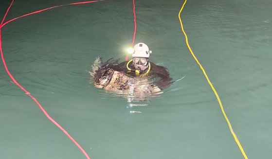 ダイバーがコカインの入ったカバンを見つけて引き揚げている様子。［写真　大邱（テグ）地検］