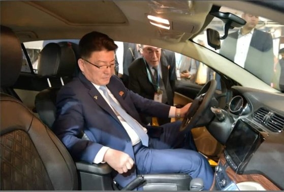 経済視察団団長として先月２３日から１０日間イランを訪問した北朝鮮の尹正浩対外経済相が第６回イラン輸出見本市でイランの自動車メーカーであるサイパのブースを訪問し車に試乗する様子。［写真　サイパ］