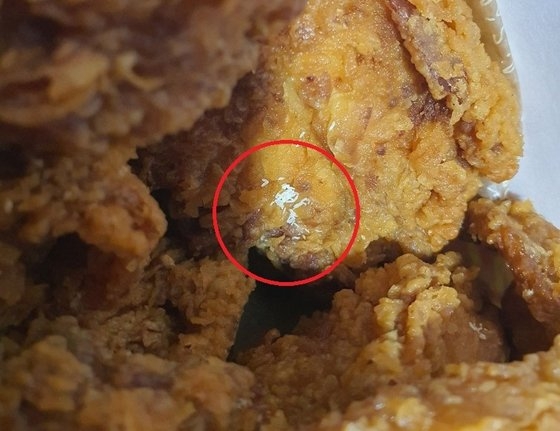 韓国のある大型マートのチキンで発見されたハエの卵と推定される物質［写真　聯合ニュース］