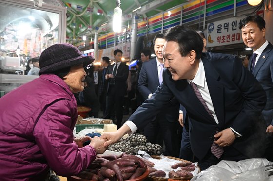 尹錫悦大統領が２月に忠清南道瑞山の伝統市場を訪問し商人らとあいさつしている。［写真　韓国大統領室］